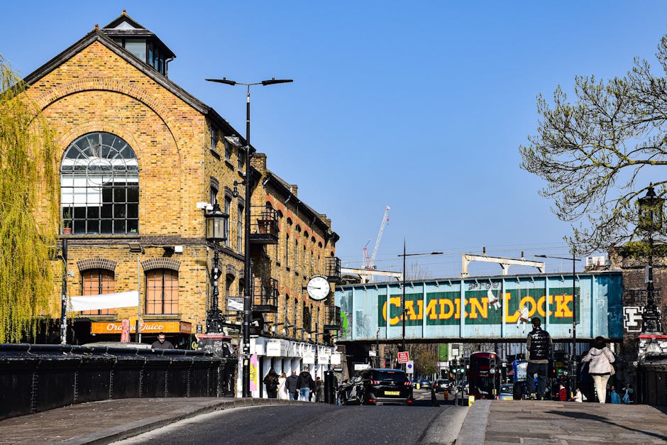 A brick wall displaying street name signs with the names 'to Branch Hill' and 'West Heath Rd' in white letters on black backgrounds, arranged in two rows with moss and weathering visible on the bricks